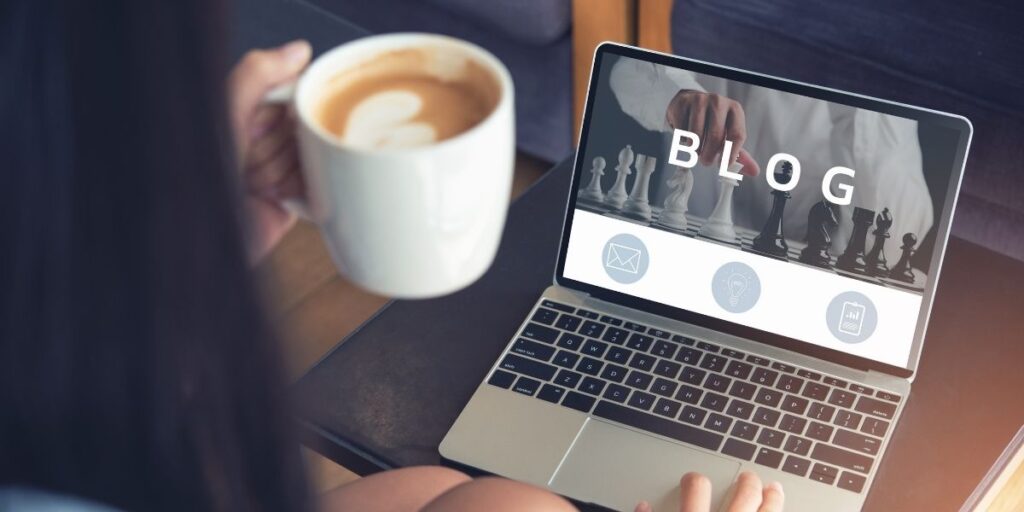 a laptop that says blog, and someone holding a coffee